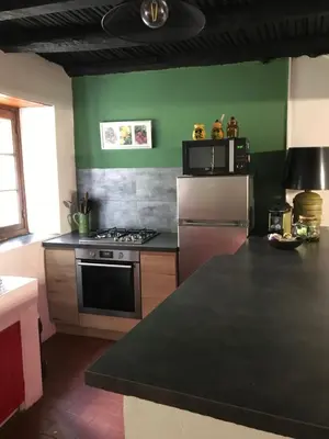 a living room with a bed and a table and chairs at Maison de village in Ortiporio