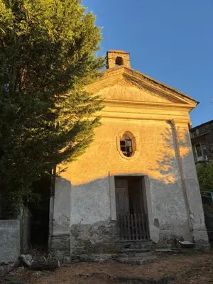 a garden with two chairs and a stone wall at Maison de village in Ortiporio
