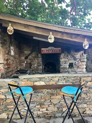 two chairs sitting in front of a stone fireplace at Casa di Emma in Santo-Pietro-di-Tenda