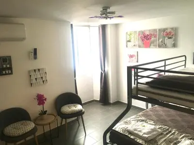 a bedroom with a bed and two chairs and a window at Casa di Emma in Santo-Pietro-di-Tenda