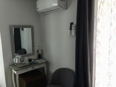 a room with a mirror and a chair and a table at Casa di Emma in Santo-Pietro-di-Tenda