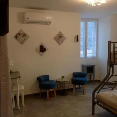 a living room with blue chairs and a piano at Casa di Emma in Santo-Pietro-di-Tenda