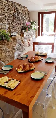 a wooden table with bread and pastries on it at A COSTA in Venzolasca