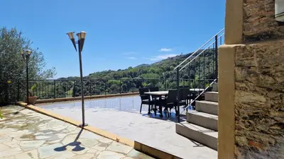 a balcony with a table and a view of a mountain at A COSTA in Venzolasca