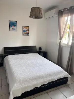 a bedroom with a white bed and two windows at Appt T2 Standing avec Piscine et Terrasse in Porto-Vecchio