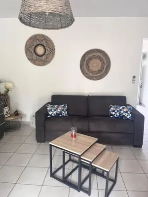 a living room with a couch and a table at Appt T2 Standing avec Piscine et Terrasse in Porto-Vecchio