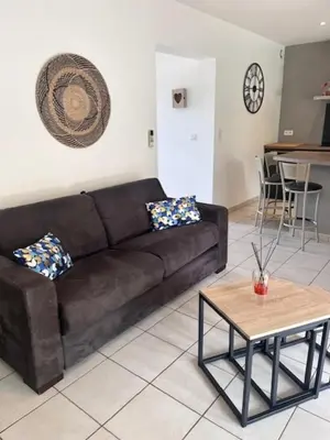 a living room with a brown couch and a table at Appt T2 Standing avec Piscine et Terrasse in Porto-Vecchio