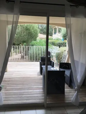 a screened porch with two chairs and a table at Appt T2 Standing avec Piscine et Terrasse in Porto-Vecchio