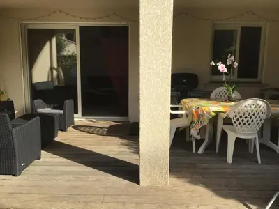 a patio with a table and chairs and a dining room at Appt T2 Standing avec Piscine et Terrasse in Porto-Vecchio