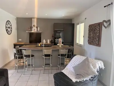 a kitchen and living room with a counter and a bar at Appt T2 Standing avec Piscine et Terrasse in Porto-Vecchio