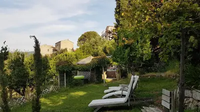 a row of white lounge chairs in a yard at la VILLA GUIDI in Pila-Canale