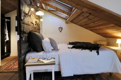 a bedroom with a white bed and a table at la VILLA GUIDI in Pila-Canale