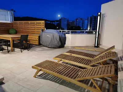 a patio with a table and chairs on a balcony at Appartement toit terrasse 2 chambres in Ajaccio