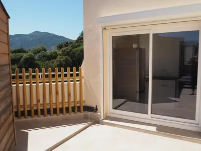 a sliding glass door on a balcony with a fence at Appartement toit terrasse 2 chambres in Ajaccio