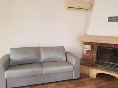 a couch in a living room with a fireplace at Appartement toit terrasse 2 chambres in Ajaccio