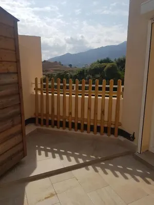 a wooden fence on a balcony with a view at Appartement toit terrasse 2 chambres in Ajaccio