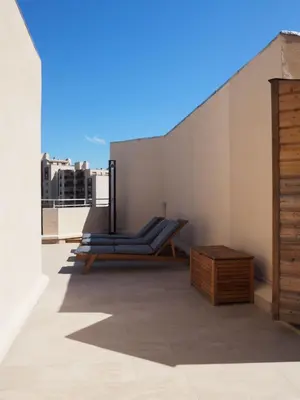 a balcony with a lounge chair and a table at Appartement toit terrasse 2 chambres in Ajaccio