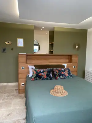 a bedroom with a bed with a hat on it at LA POINTE D’ASPRETTO in Ajaccio