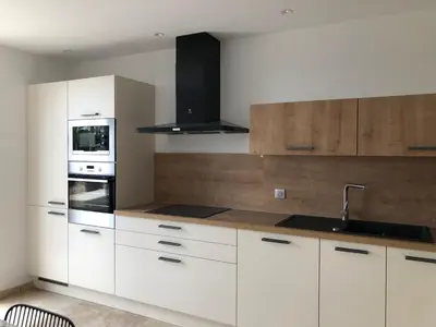 a kitchen with white cabinets and a sink and a stove at LA POINTE D’ASPRETTO in Ajaccio