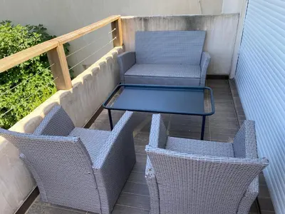 two chairs and a table on a balcony at BAVELA in Porto-Vecchio