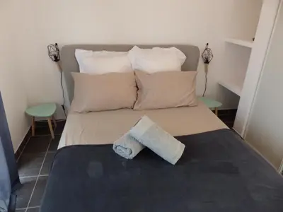 a bed in a room with a pillow on it at BAVELA in Porto-Vecchio