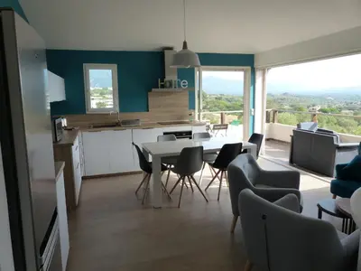 a kitchen and dining room with a table and chairs at BAVELA in Porto-Vecchio