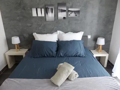 a bedroom with a bed with blue sheets and pillows at BAVELA in Porto-Vecchio