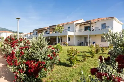 a house with flowers in front of it at Résidence Odalys Acqua Bella in Poggio-Mezzana