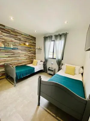 a bedroom with two beds and a wall at Villa entre Mer et Montagne... in Calenzana