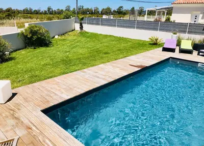 a backyard with a swimming pool and a lawn at Villa entre Mer et Montagne... in Calenzana