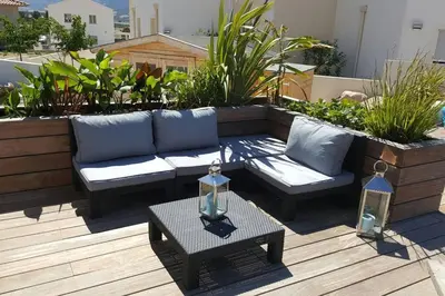 a patio with a couch and a table on a roof at Villa entre Mer et Montagne... in Calenzana