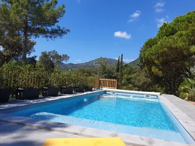 a swimming pool with chairs and mountains in the background at Casa San Niolo in Cervione