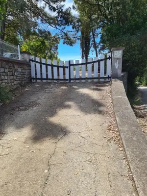 a white fence sitting next to a dirt road at Casa San Niolo in Cervione