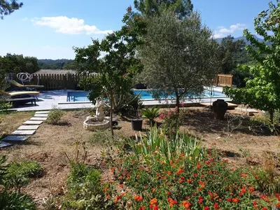 a garden with a swimming pool and trees and flowers at Casa San Niolo in Cervione