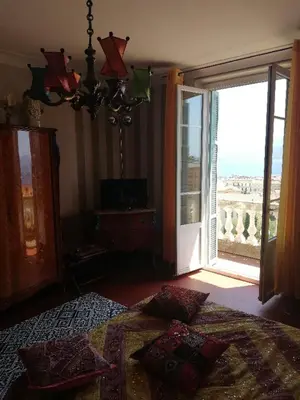 a bedroom with a bed and a large sliding glass door at Villa Cécile in Ajaccio