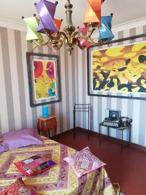 a bedroom with a bed and a chandelier at Villa Cécile in Ajaccio