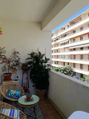 a balcony with tables and potted plants and a building at Villa Cécile in Ajaccio