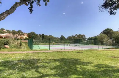 a tennis court in a park with a tennis court at Appartement 2 pièces Pied dans l'eau in Porto-Vecchio
