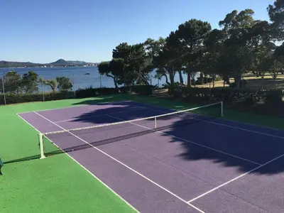 a tennis net on a tennis court next to the water at Appartement 2 pièces Pied dans l'eau in Porto-Vecchio