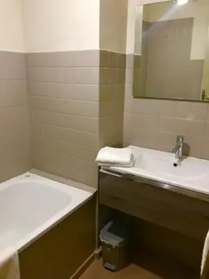 a bathroom with a sink and a bath tub at Les résidences du port appartements meublés in Porto Ota