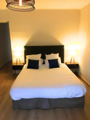 a bedroom with a large white bed with two lamps at Les résidences du port appartements meublés in Porto Ota