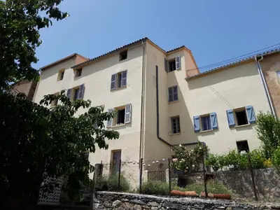 a large white building with a fence in front of it at Casa Franceschi in Pioggiola