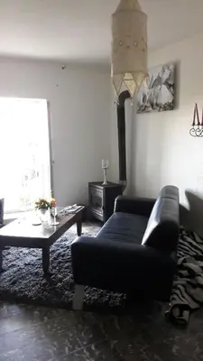 a living room with a black couch and a table at Casa Franceschi in Pioggiola
