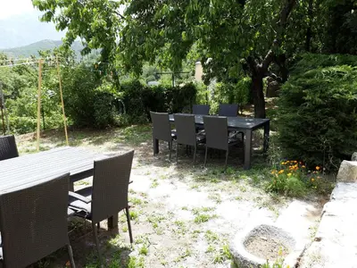 a black table and chairs sitting under a tree at Casa Franceschi in Pioggiola