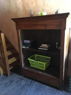 a book shelf with a green basket in a room at maison de village T4 in Poggio-dʼOletta