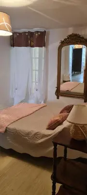 a bedroom with a bed and a large mirror at maison de village T4 in Poggio-dʼOletta