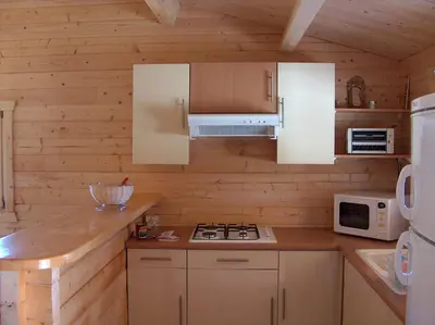 a kitchen with white cabinets and a stove and microwave at chalet climatisé Porticcio Corse in Fontanaccio