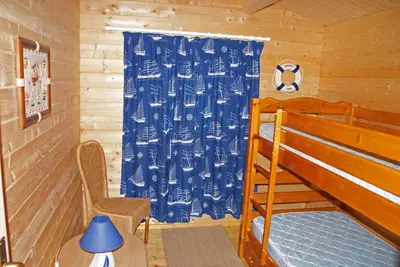 a bedroom with a bed and a blue curtain at chalet climatisé Porticcio Corse in Fontanaccio