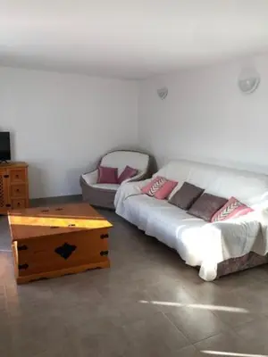 a room with two beds and a coffee table at Villa Lucie Paul rez de jardin à Méla in Mela