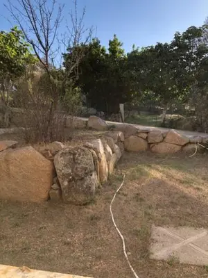 a stone wall with rocks in a zoo at Villa Lucie Paul rez de jardin à Méla in Mela